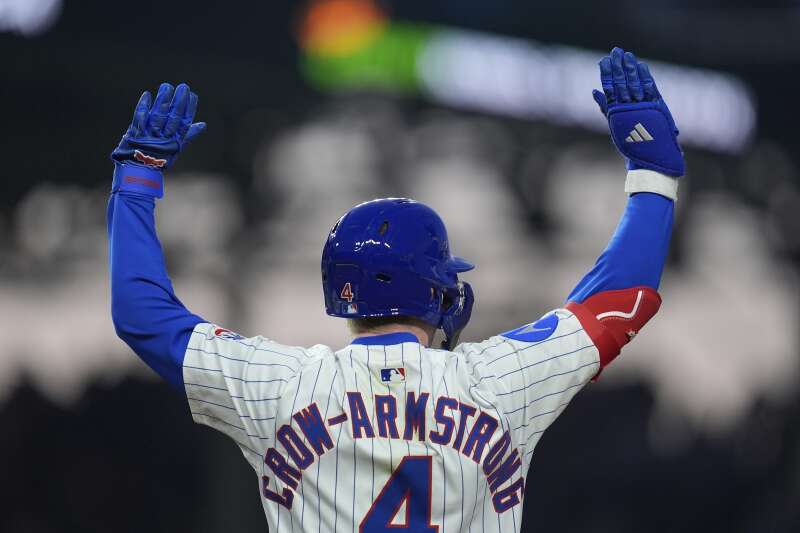 Cubs player wearing Crow-Armstrong’s number four jersey raises both hands.